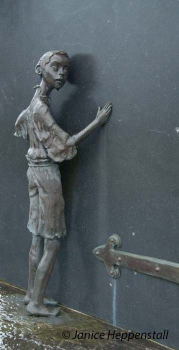 Part of memorial to the Great Famine of 1845-1850 showing small orphaned boy waiting at a door.